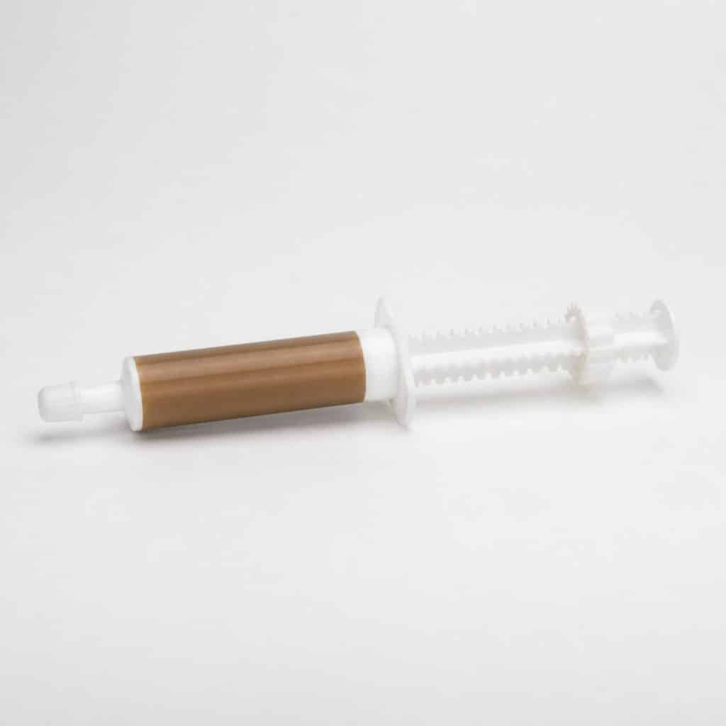 Seringue doseuse de pâte vermifuge pour chat sur fond blanc